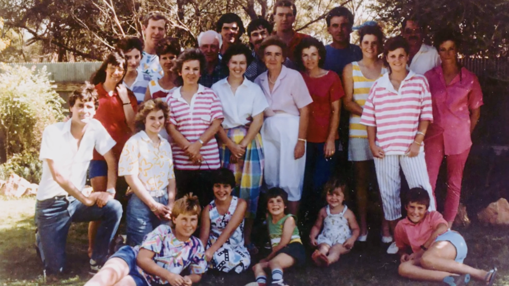 Old photograph of over 20 people gathered in a backyard